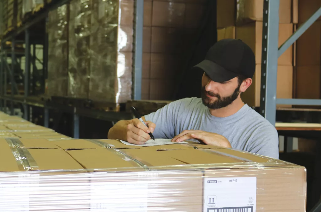Shipping employee writing on box